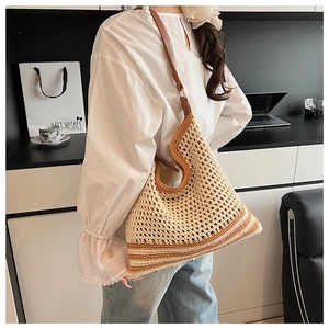 Detail of crochet tote bag with brown leather strap and striped knit texture