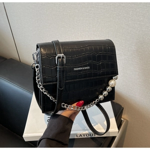 Detail of black stone-patterned crossbody bag with silver chain and pearl handle decor