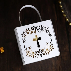 Detail of laser-cut cross wreath on white gift box with gold interior and white handle