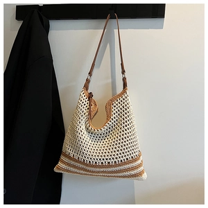 Detail of hand-woven hollow mesh tote bag with brown leather strap and summer stripes