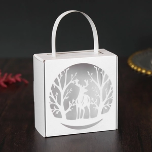 Detail of laser-cut white Christmas reindeer gift box with elegant forest silhouettes