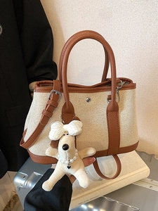 Large canvas bucket bag with brown leather trim and cute plush dog charm accessory