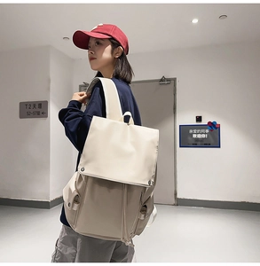 Cream vintage backpack featuring a large flap closure and utility style side pockets