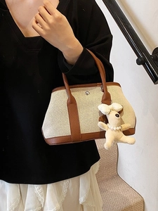 Large beige canvas tote bag with brown leather trim and a cute plush dog charm