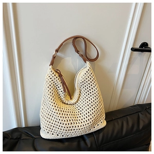 Detail of cream woven tote bag with brown leather shoulder strap and zip closure
