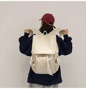 Detail view of large capacity cream white vintage backpack with drawstring and flap closure