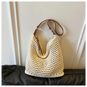 Detail of crochet straw tote with brown leather handles and secure zipper closure