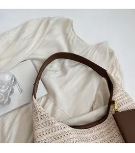 Detail of hand-woven straw hobo bag with brown leather shoulder strap and mini pouch