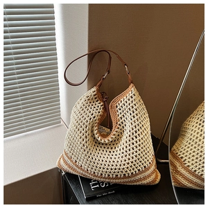 Detailed macro view of bohemian crochet tote bag with brown leather strap and metal rings