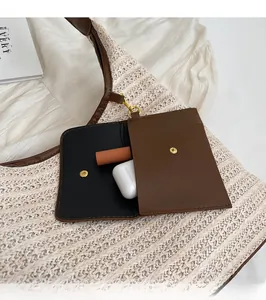 Detail view of woven straw bag with leather trim and removable small pouch for accessories