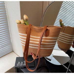 Detail of striped woven tote bag with brown leather straps and summer vacation style