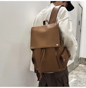 Detail view of vintage brown leather backpack with drawstring closure and silver buckles