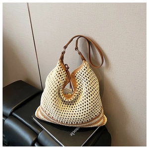 Detailed macro view of hollow-out mesh woven straw tote with premium brown leather handle