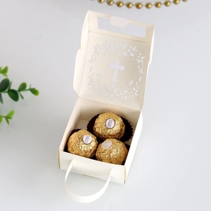 Detail of laser-cut cross and floral hollow design on white wedding favor gift bag