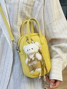 Yellow pebble leather mini handbag with a cute teddy bear charm and thin shoulder strap
