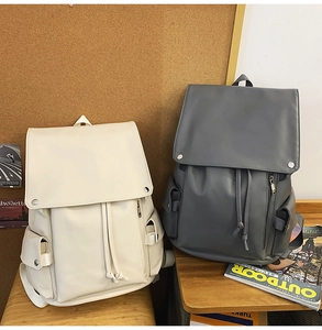 Detailed close-up showing matte PU leather texture and drawstring flap on travel backpacks
