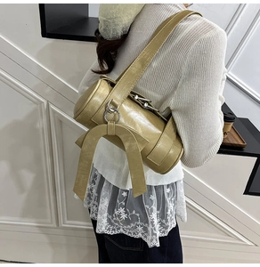Detail of light green Boston bag with bow accent and textured PU leather surface