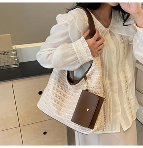 Detail of woven tote bag with brown leather straps and matching hanging pouch