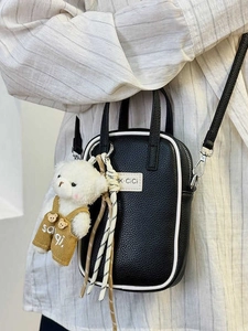 Vertical black lychee grain mini crossbody bag with white piping and plush bear charm
