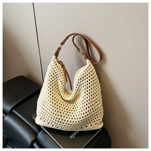 Detail of beige crochet knit beach tote bag with brown leather shoulder straps
