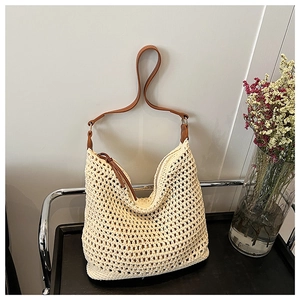 Detail of handwoven beige cotton tote bag featuring contrast brown leather shoulder straps