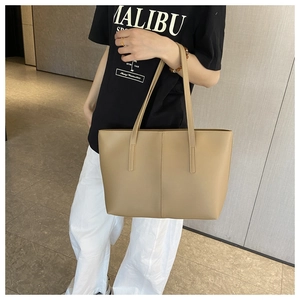 Detailed view of the large capacity tote bag featuring vertical stitching and leather texture