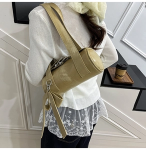 Detail of khaki Boston bag with stylish tassels and metallic ring on the shoulder strap