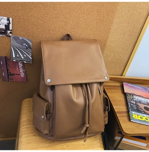 Detailed view of a vintage brown PU leather backpack with drawstring and metal snaps