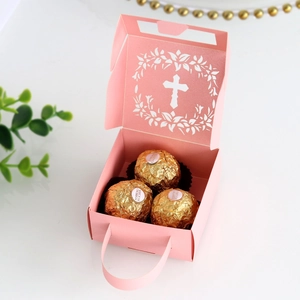 Detailed top view of pink wedding favor box with hollow cross and gold chocolates