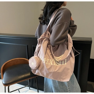 Detailed side view of purple drawstring canvas tote bag with matching round mini pouch