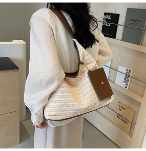 Close-up of the beige woven hobo bag with dark brown leather trim and mini pouch detail