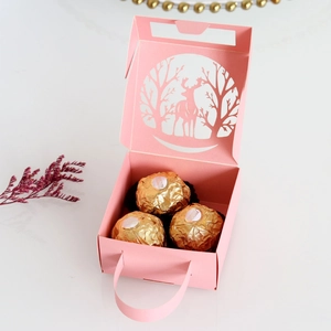 Detail of pink laser-cut Christmas candy box with reindeer patterns and hand strap