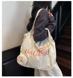 Detail view of cream white nylon tote bag with drawstring closure and mini round coin pouch