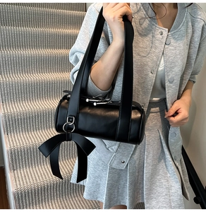Détail du sac polochon Boston noir en cuir avec grand pendentif nœud et fermeture argentée