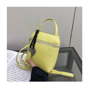 Close-up of yellow lychee pattern mini bag featuring a silver heart charm and strap