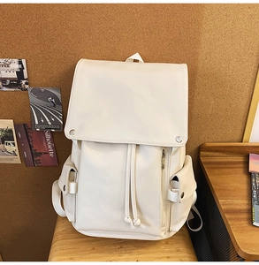Close-up of off-white PU leather backpack with flap cover and drawstring closure details