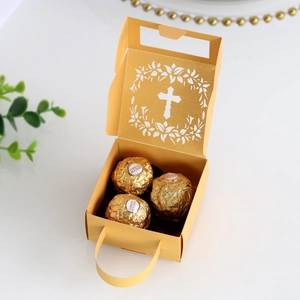 Detail of golden gift box with hollow cross pattern, holding three spherical chocolates