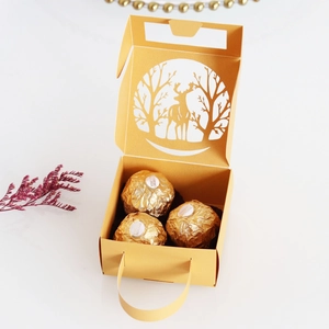 Detail of laser-cut reindeer and forest patterns on a gold Christmas candy gift box