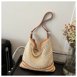 Detail of crochet knit hobo bag with contrast strap on a decorative shelf
