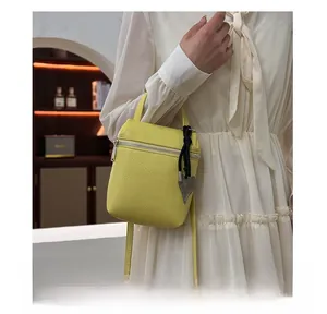 Détail du sac à bandoulière en cuir jaune grainé avec pendentif en forme de cœur