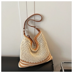 Detailed view of bohemian woven straw tote with leather strap and secure zipper closure