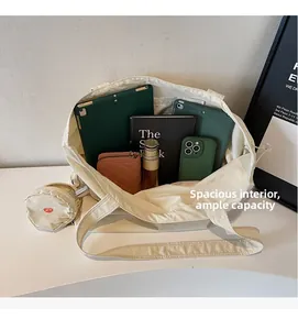 Detail view of large beige canvas tote bag showing interior capacity with gadgets