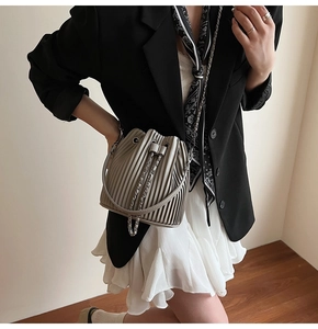 Fashionable grey pleated bucket bag with silver chain strap and drawstring closure details