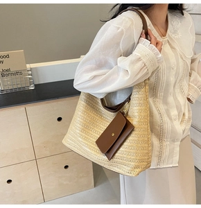 Macro detail of hand-woven straw tote bag with brown leather accessory and shoulder strap