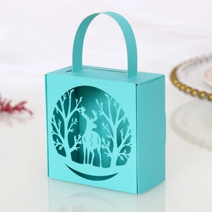 Close-up of Tiffany blue laser-cut reindeer and forest patterns on a gift candy box