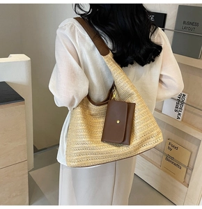 Detailed back view of a woven tote bag with brown leather straps on a model