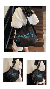 Detail of black large tote bag with blue DAIXISHI logo and matching mini coin purse