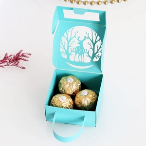 Close-up of laser-cut reindeer and forest pattern on a blue Christmas candy gift box