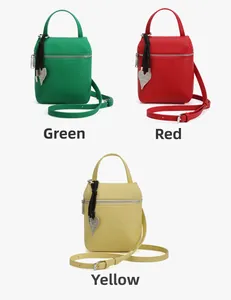 Détails de petits sacs à main en cuir grainé vert, rouge et jaune avec charms en cœur