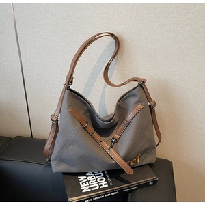 Detail of grey canvas tote bag with brown leather straps and TCT letter branding